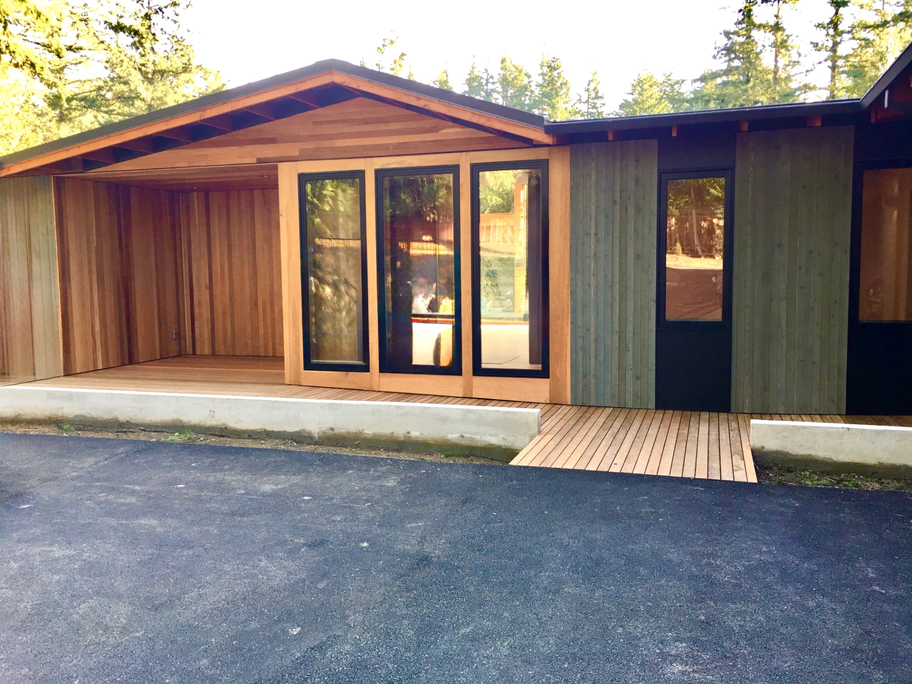 Cedar-clad entry with covered porch, ipe decking and full-height glass doors