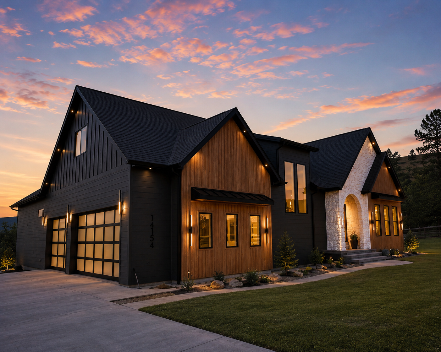 Front exterior of 14154 Saddle Hill Drive at dusk with black vertical siding, warm wood gable, white stone entry and glowing garage doors